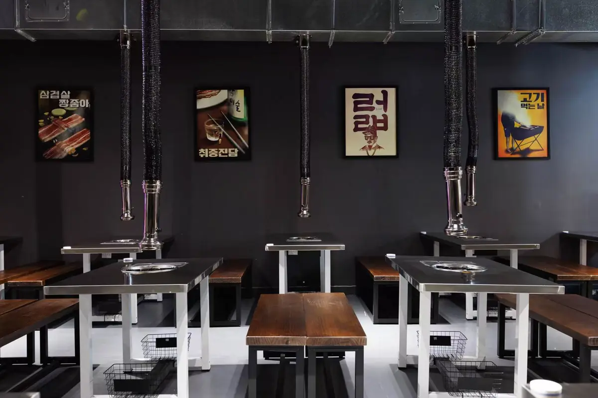 Korean posters above grill tables in the GOGI dining room